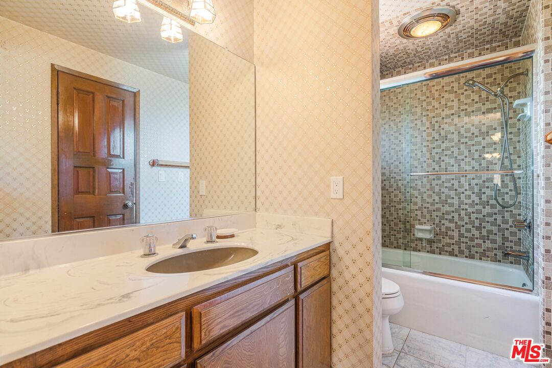 1181 Somera Road Los Angeles, CA 90077 - Photo 25 of 40 a bathroom with a granite countertop sink and a mirror