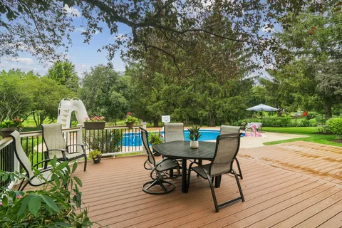 a view of a roof deck with table and chairs and wooden floor