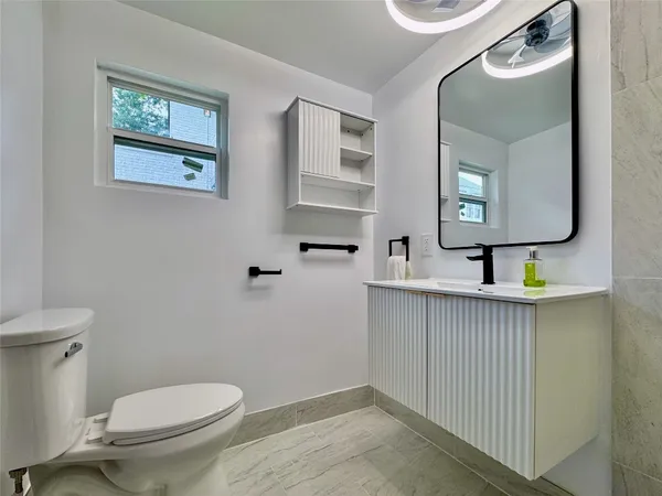 a bathroom with a toilet a sink and mirror