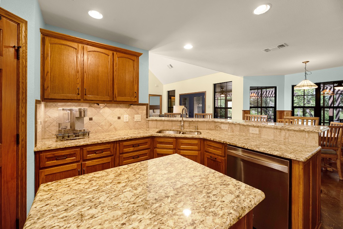 1546 Cox Road Blanco, TX 78606 - Photo 11 of 40 a kitchen with stainless steel appliances granite countertop wooden cabinets a sink and dishwasher
