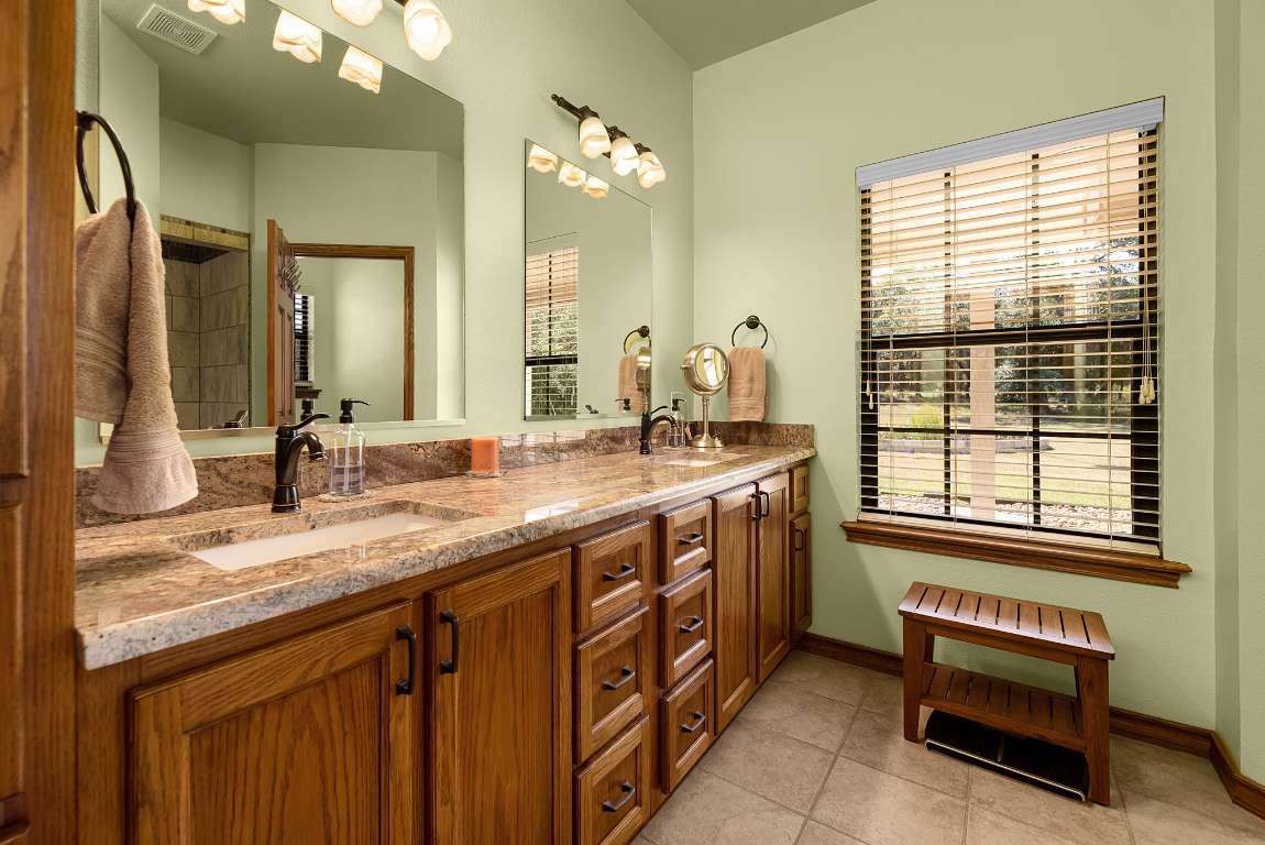 1546 Cox Road Blanco, TX 78606 - Photo 18 of 40 a bathroom with a granite countertop sink and a large mirror