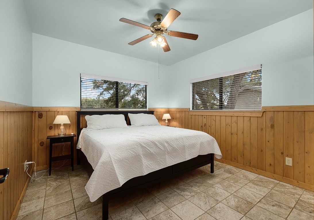 1546 Cox Road Blanco, TX 78606 - Photo 25 of 40 a bedroom with a bed and a chandelier