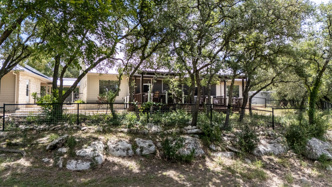 1546 Cox Road Blanco, TX 78606 - Photo 35 of 40 a backyard of a house with lots of plants and trees