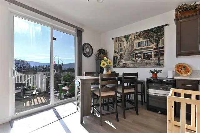 a kitchen with stainless steel appliances kitchen island granite countertop a refrigerator a stove a sink and chairs with wooden floor