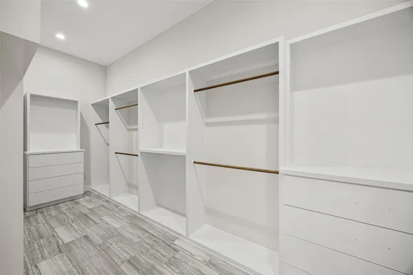a view of walk in closet with empty racks