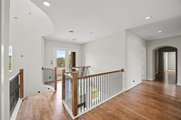 a view of a hallway with furniture and wooden floor