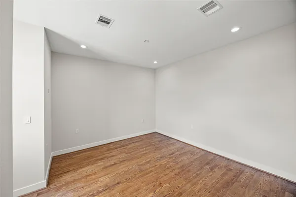 a view of empty room with wooden floor