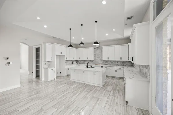 a large kitchen with a lot of counter space and stainless steel appliances