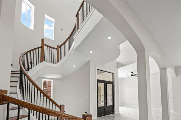 a view of staircase with railing and white walls