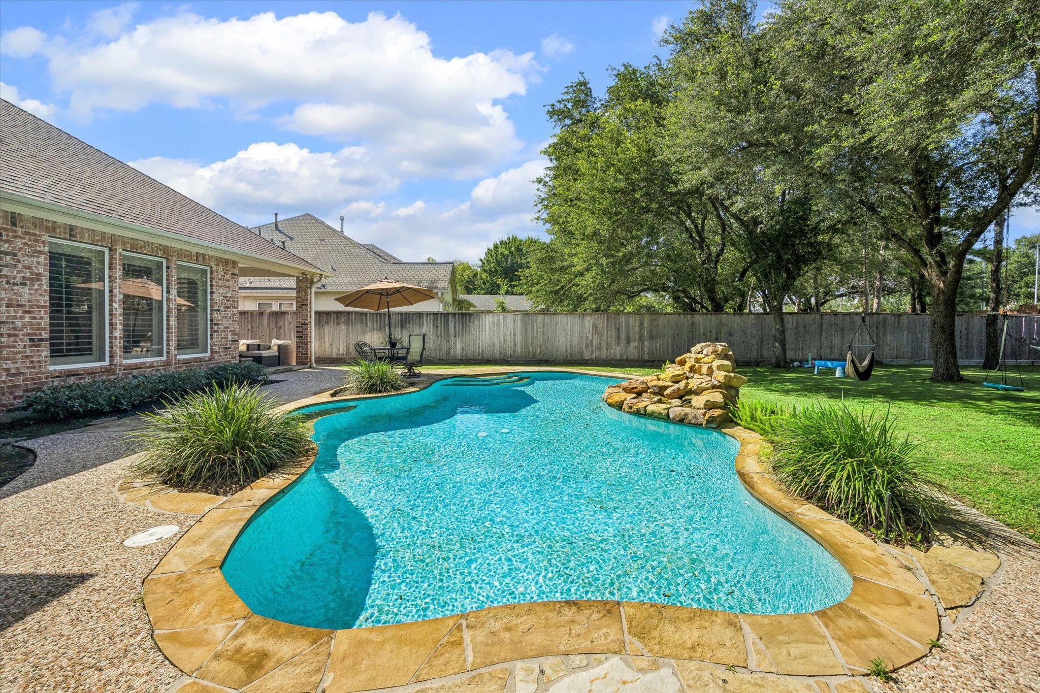 3047 Bonnebridge Way Boulevard Houston, TX 77082 - Photo 24 of 50 Refreshing pool serves as the centerpiece of the resort-inspired backyard, offering the perfect place to swim, unwind, and enjoy the outdoors. Designed to enhance the home's private retreat, it provides an exceptional setting for summer entertaining, family gatherings, and leisurely afternoons in a tranquil setting.