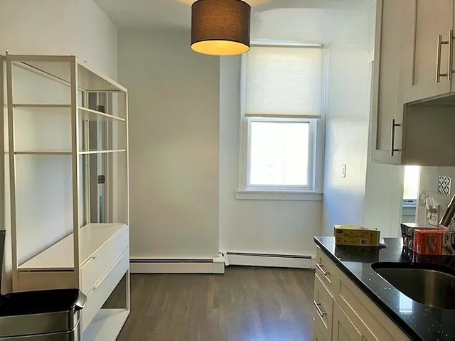 a kitchen with granite countertop a sink a stove and a window