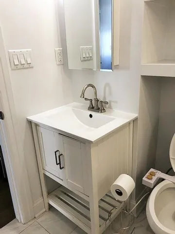 a bathroom with a sink toilet and mirror
