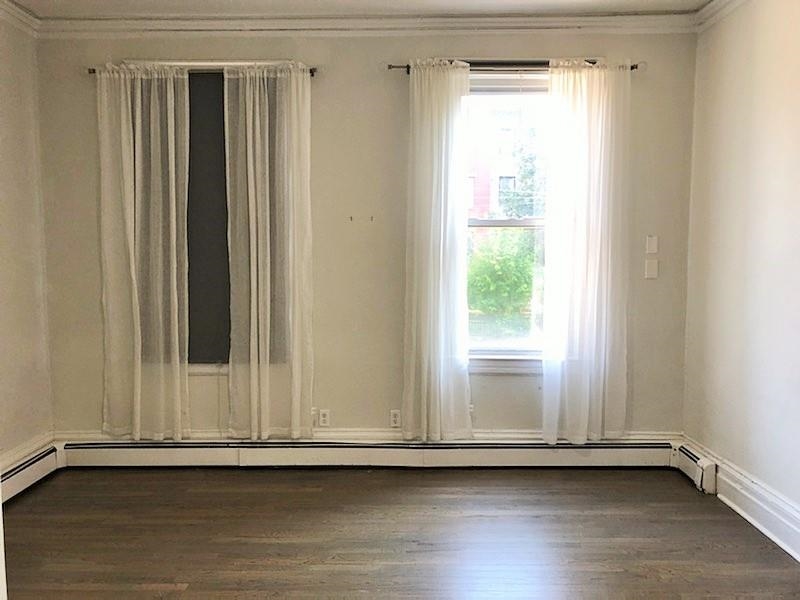 297 4th Street, Unit 2 Jersey City, NJ 07302 - Photo 4 of 19 a view of an empty room with wooden floor and a window