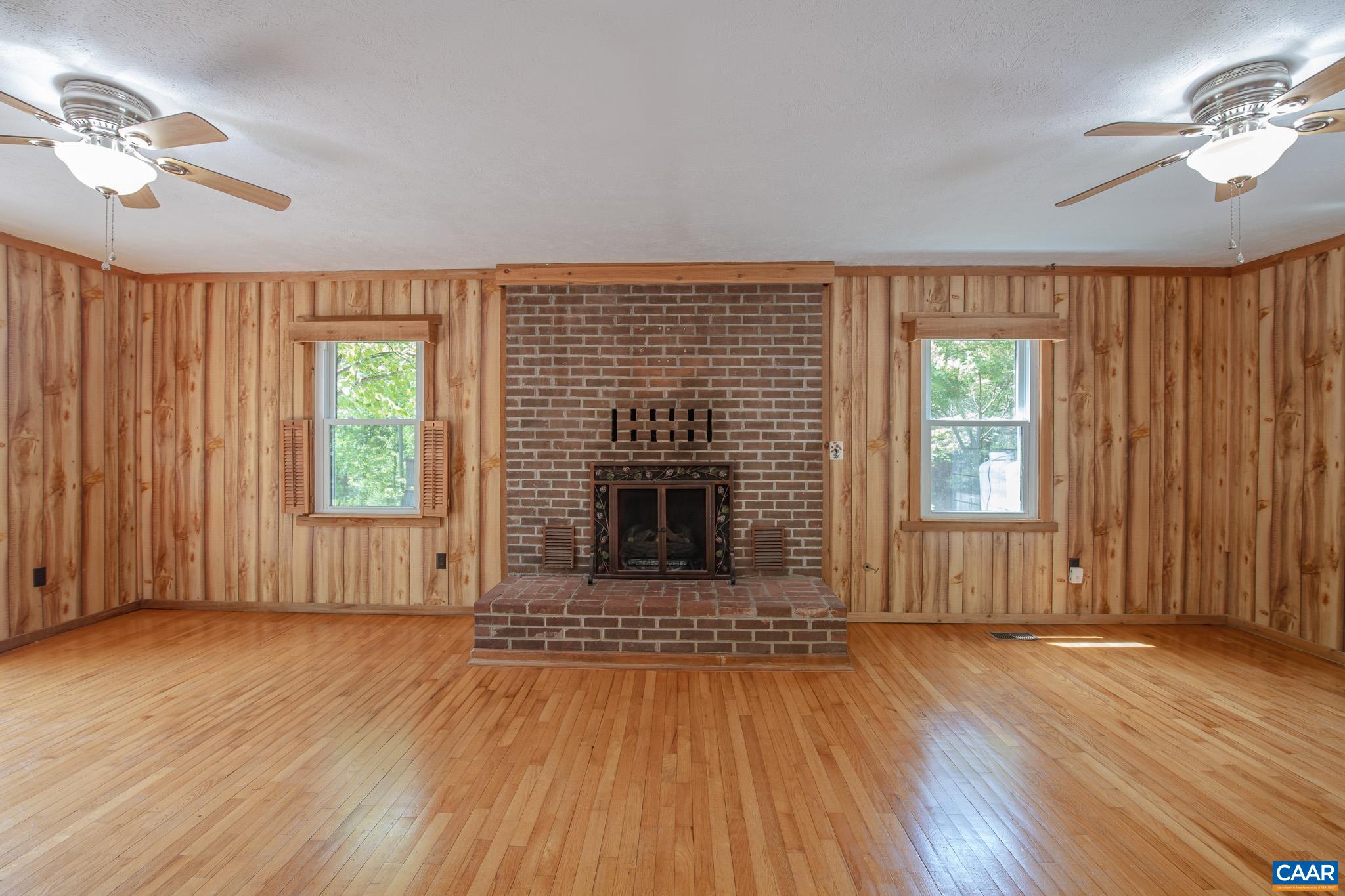 3033 Bacon Hollow Road Dyke, VA 22935 - Photo 14 of 66 an empty room with wooden floor fireplace and windows