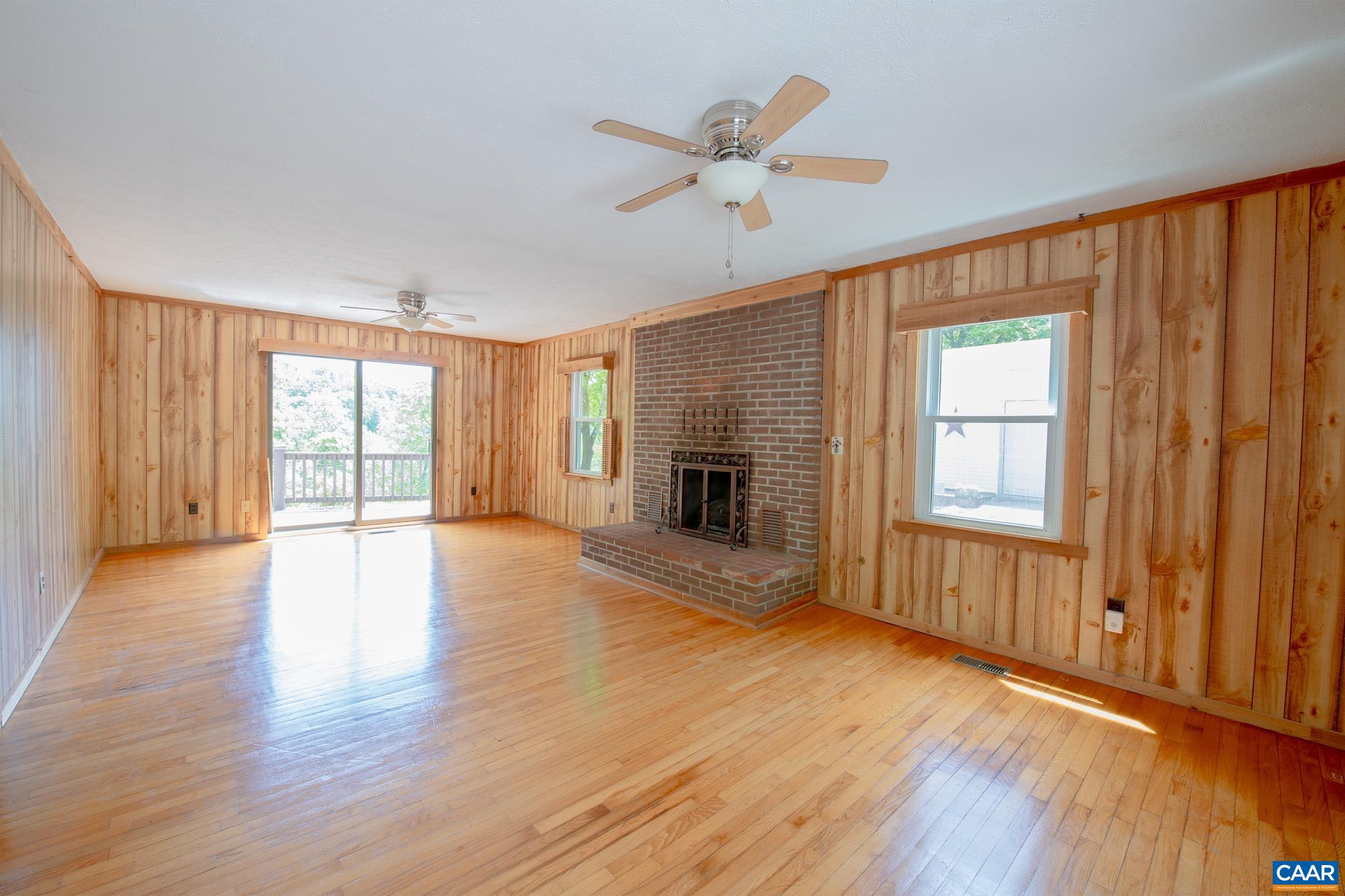 3033 Bacon Hollow Road Dyke, VA 22935 - Photo 15 of 66 an empty room with wooden floor fan and windows