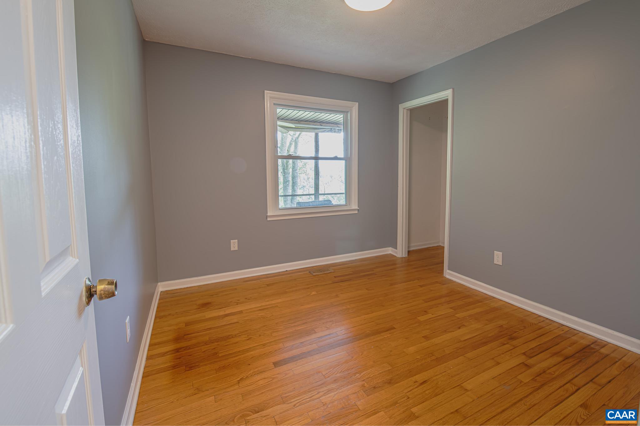 3033 Bacon Hollow Road Dyke, VA 22935 - Photo 23 of 66 a view of an empty room with wooden floor and a window