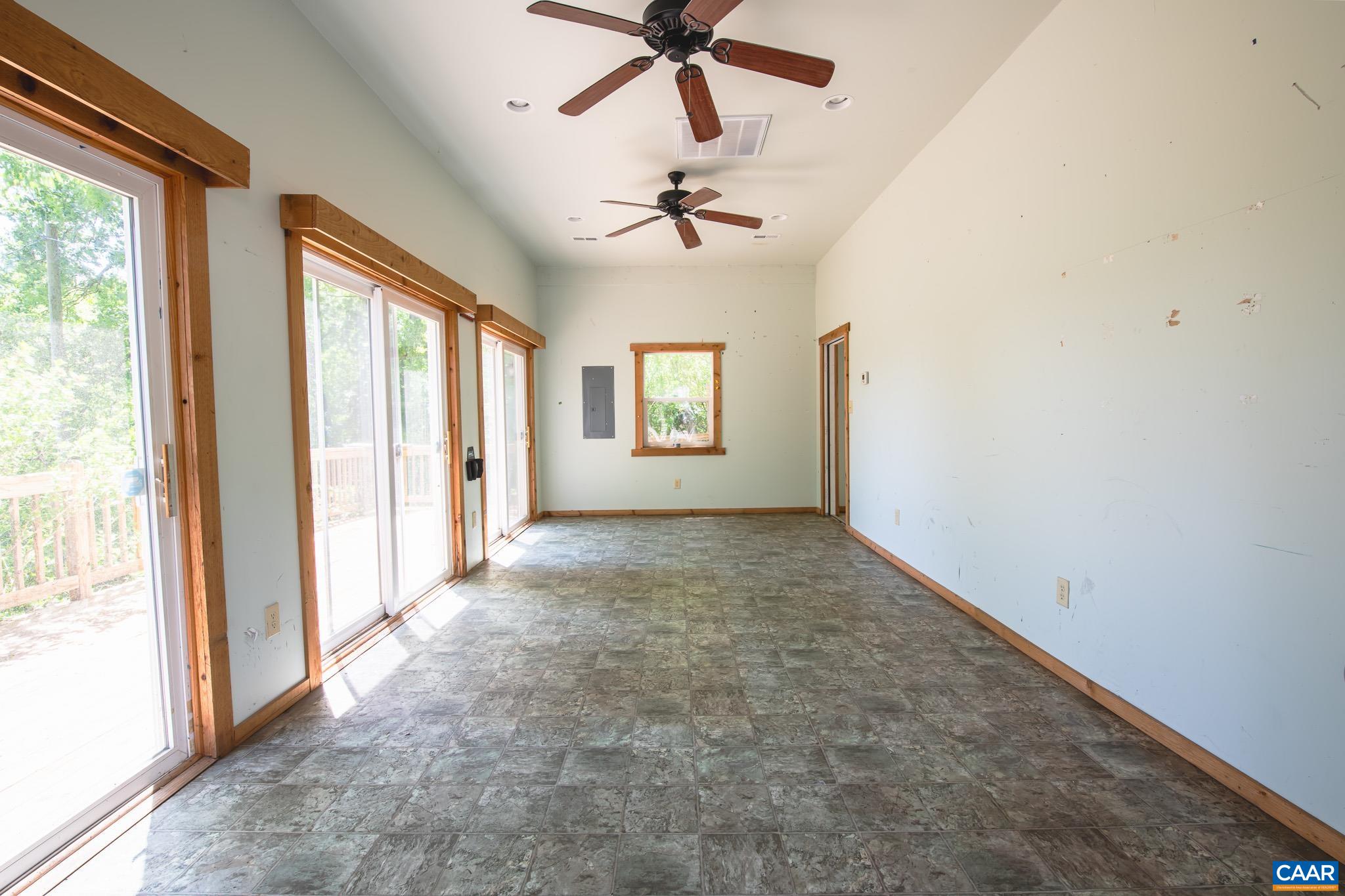 3033 Bacon Hollow Road Dyke, VA 22935 - Photo 31 of 66 en empty room with windows and ceiling fan