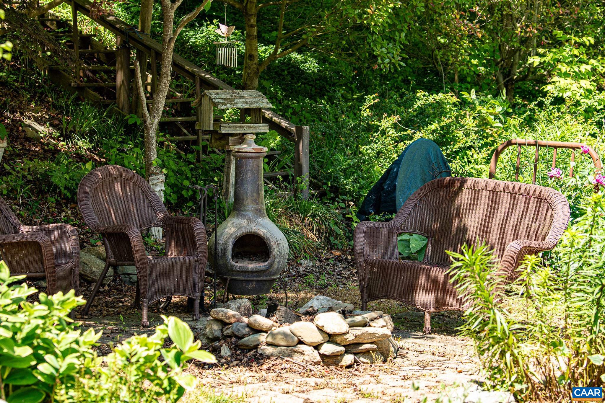 3033 Bacon Hollow Road Dyke, VA 22935 - Photo 36 of 66 a backyard of a house with fountain table and chairs