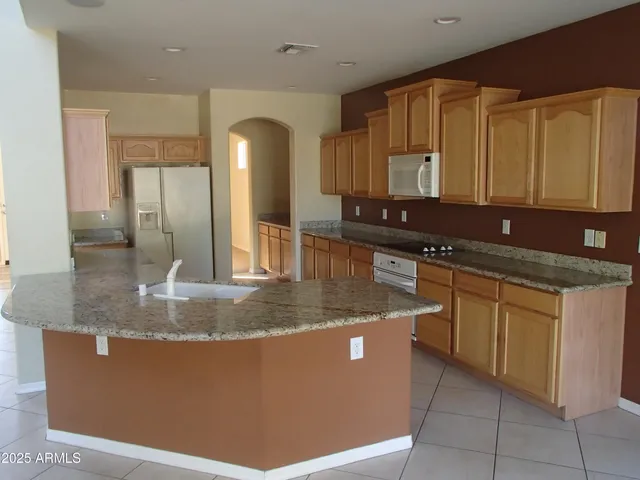 a kitchen with kitchen island a sink a counter top space and cabinets