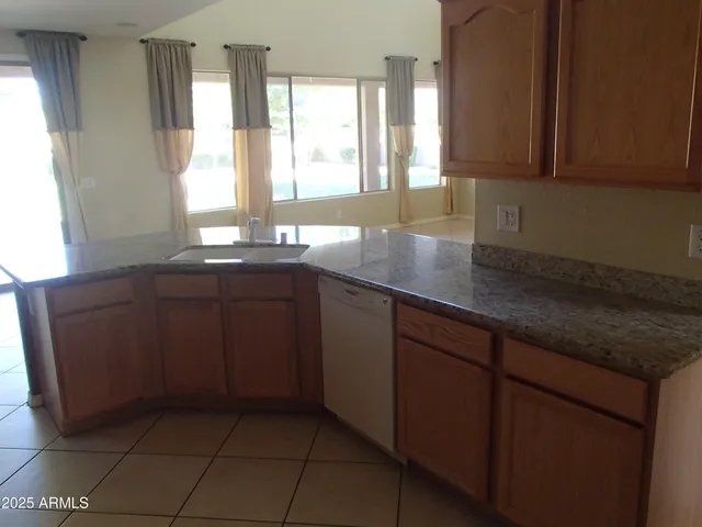 a kitchen with stainless steel appliances granite countertop a sink a stove and a microwave