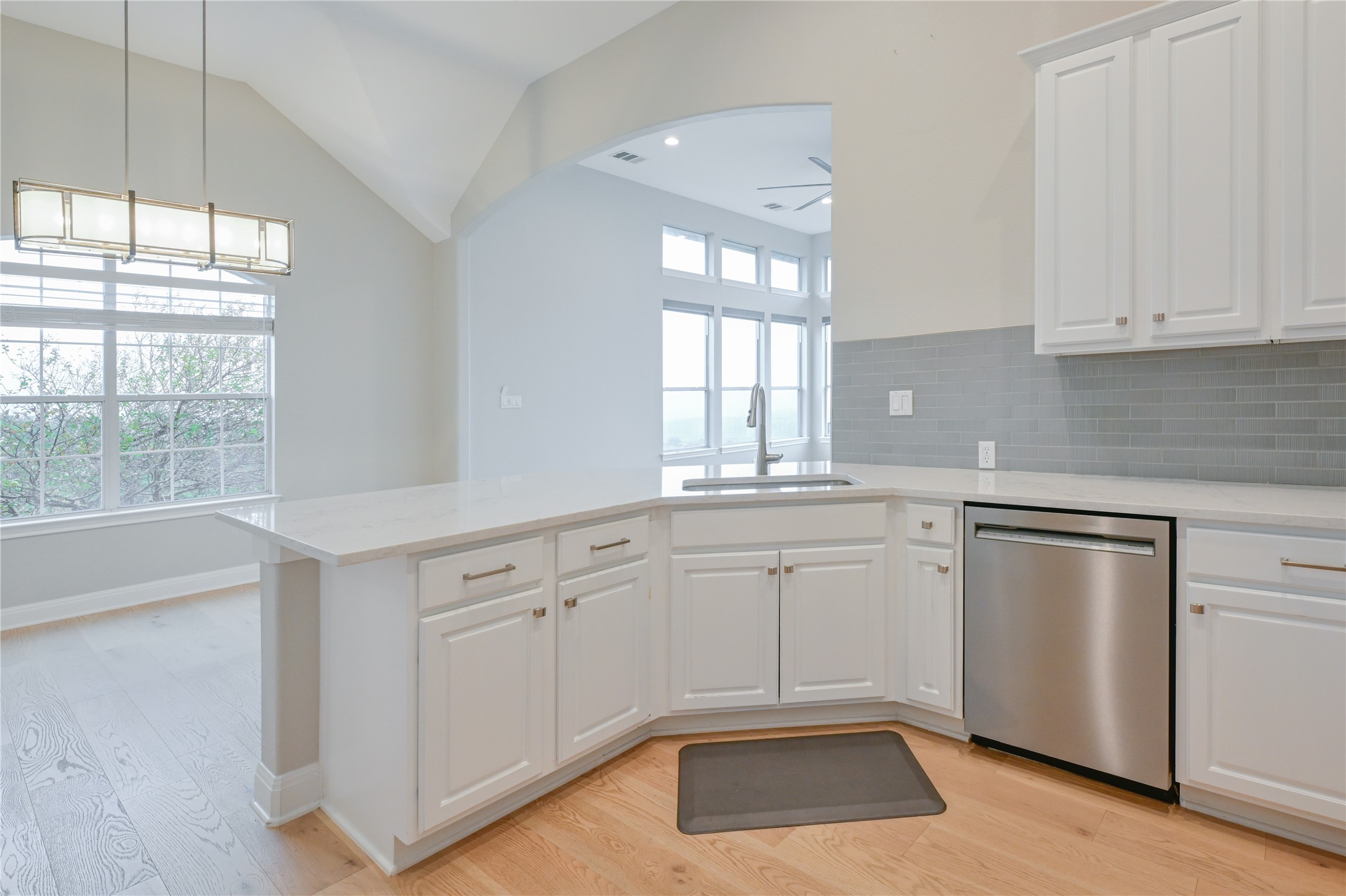 232 Sunrise Ridge Loop Austin, TX 78738 - Photo 11 of 37 Kitchen featuring white cabinetry, light countertops, and a gray subway tile backsplash