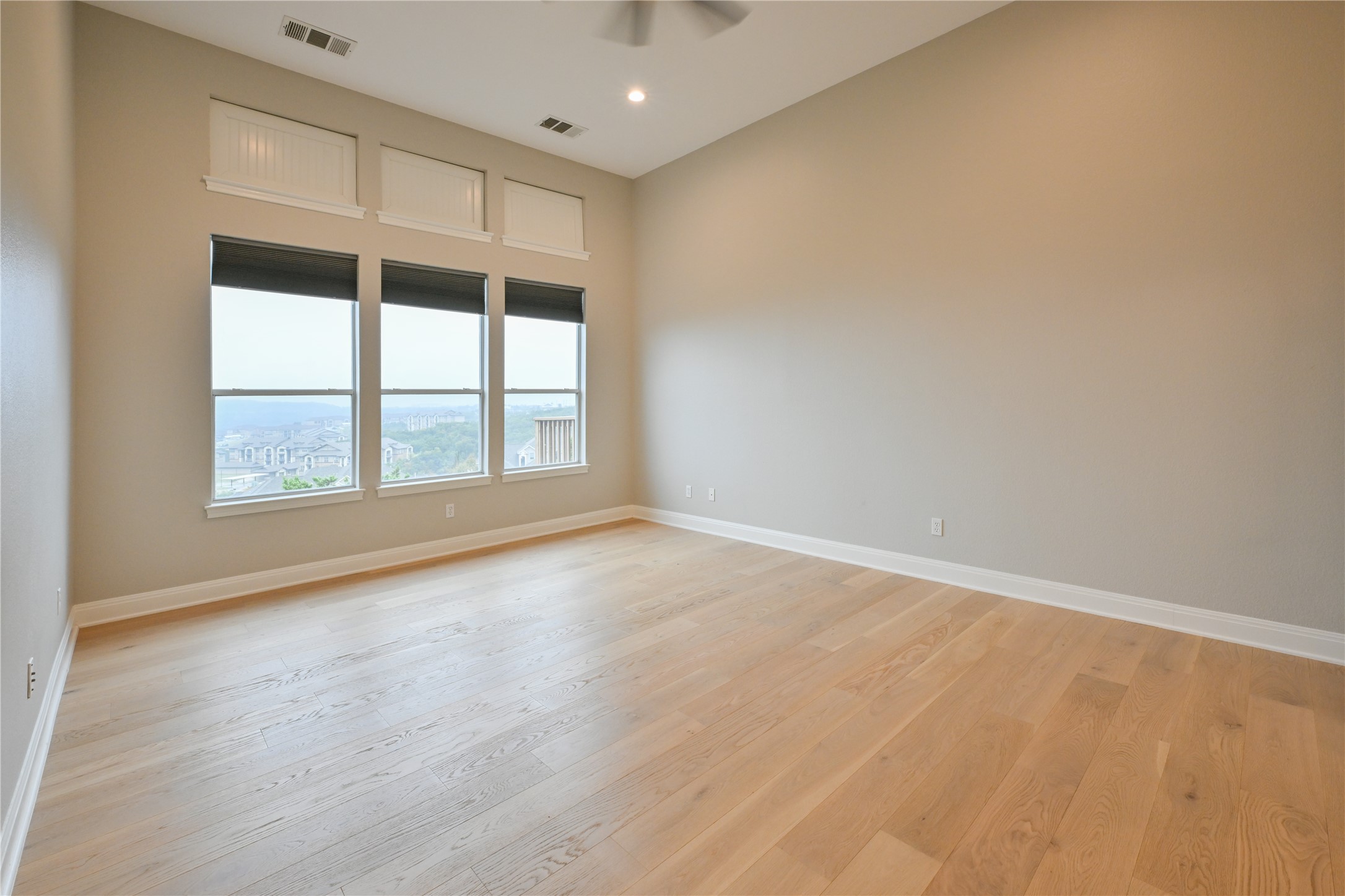 232 Sunrise Ridge Loop Austin, TX 78738 - Photo 15 of 37 Expansive room featuring light wood-finish flooring, high vaulted ceilings, and a wall of three large windows with roller shades