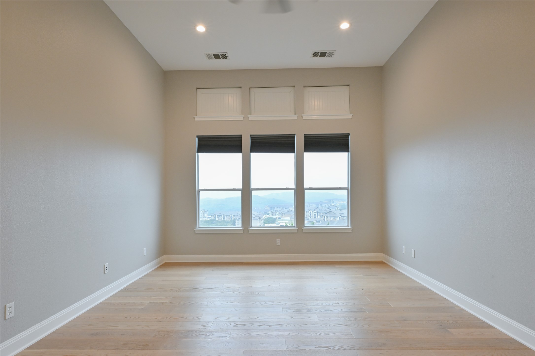 232 Sunrise Ridge Loop Austin, TX 78738 - Photo 16 of 37 Spacious room with light wood-finish flooring, high ceilings, recessed lighting, and expansive windows