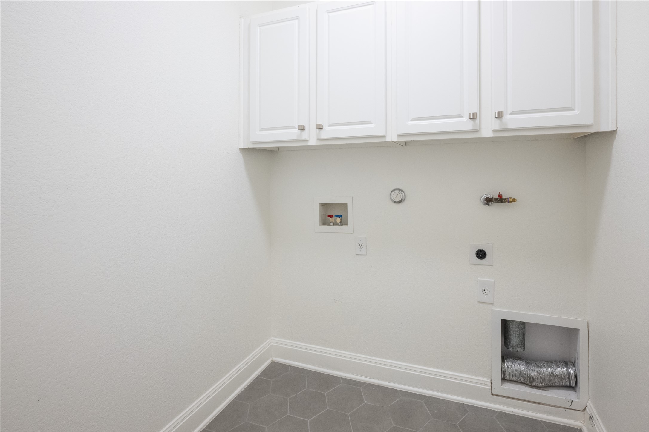 232 Sunrise Ridge Loop Austin, TX 78738 - Photo 29 of 37 Utility room featuring white shaker-style cabinetry with brushed nickel hardware, gray hexagonal floor tiles, and white baseboards