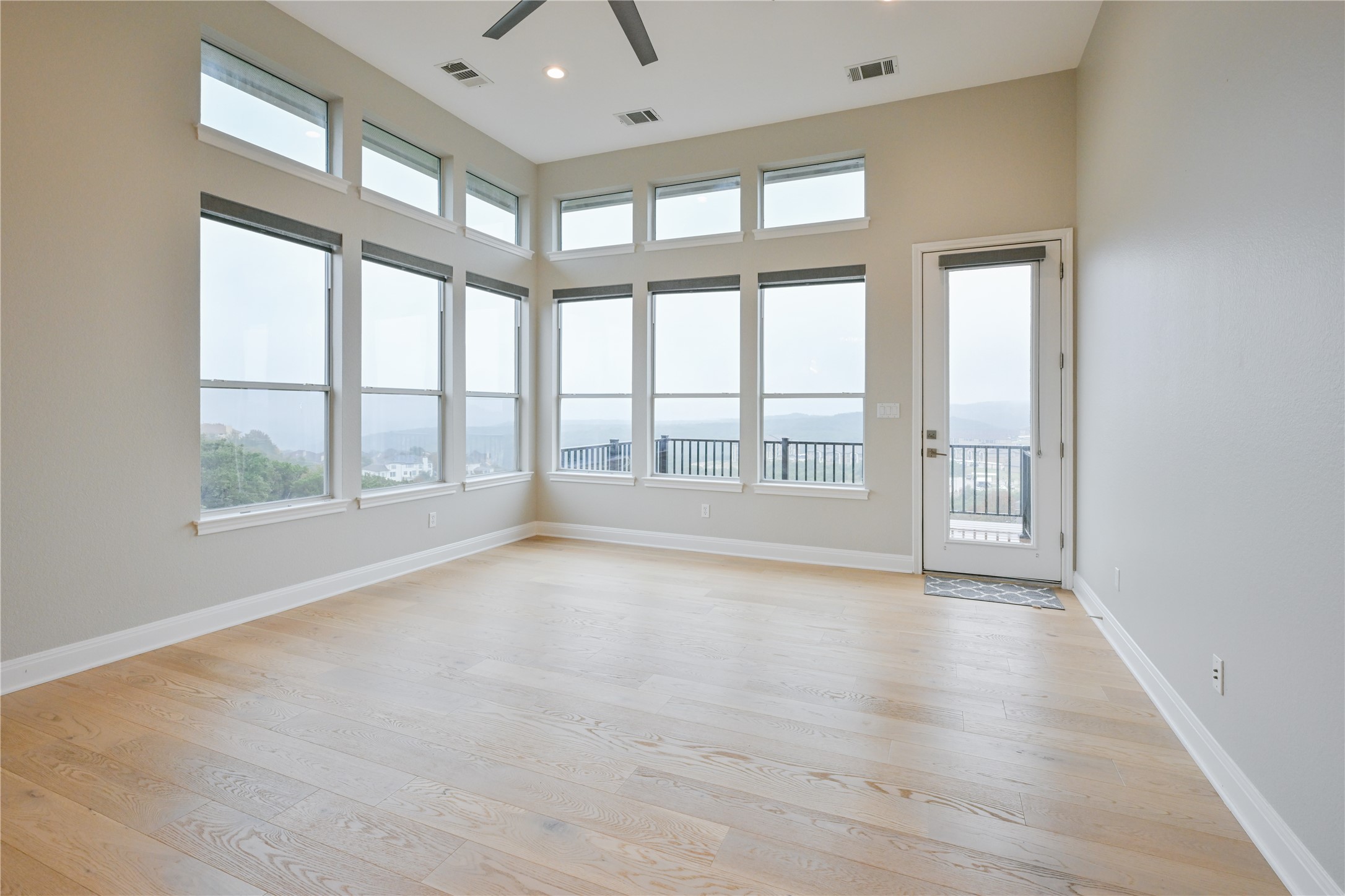 232 Sunrise Ridge Loop Austin, TX 78738 - Photo 4 of 37 Expansive room featuring light wood-finish flooring, high ceilings with recessed lighting, and a modern ceiling fan