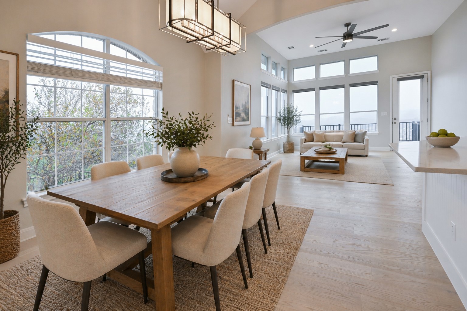 232 Sunrise Ridge Loop Austin, TX 78738 - Photo 5 of 37 Open-concept living space featuring high ceilings, light wood-finish flooring, a contemporary chandelier, and extensive fenestration with an arched transom window