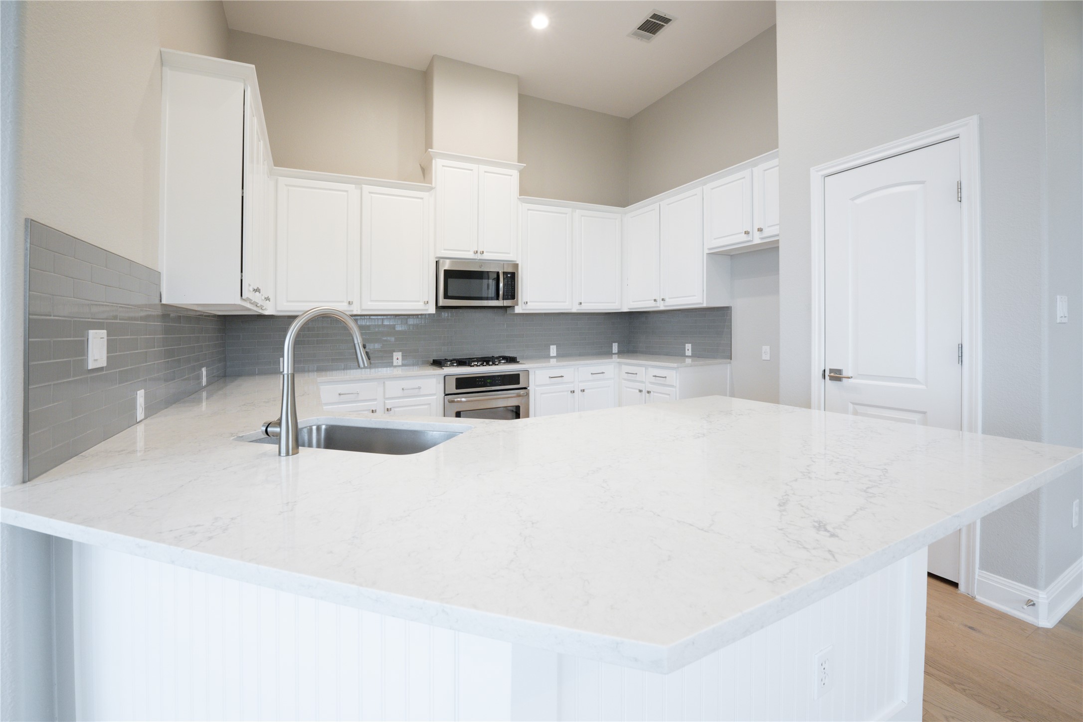 232 Sunrise Ridge Loop Austin, TX 78738 - Photo 9 of 37 Spacious kitchen island with light-toned countertop, complete with an undermount sink and brushed nickel faucet