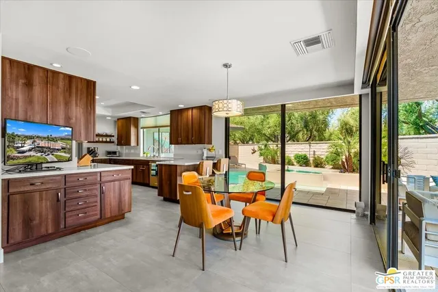 a kitchen with a table chairs and a view of living room