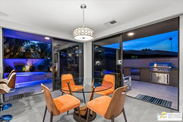 a kitchen with stainless steel appliances kitchen island granite countertop a sink dishwasher and a dining table with chairs