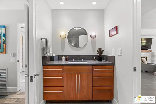 a bathroom with a granite countertop sink a mirror and shower