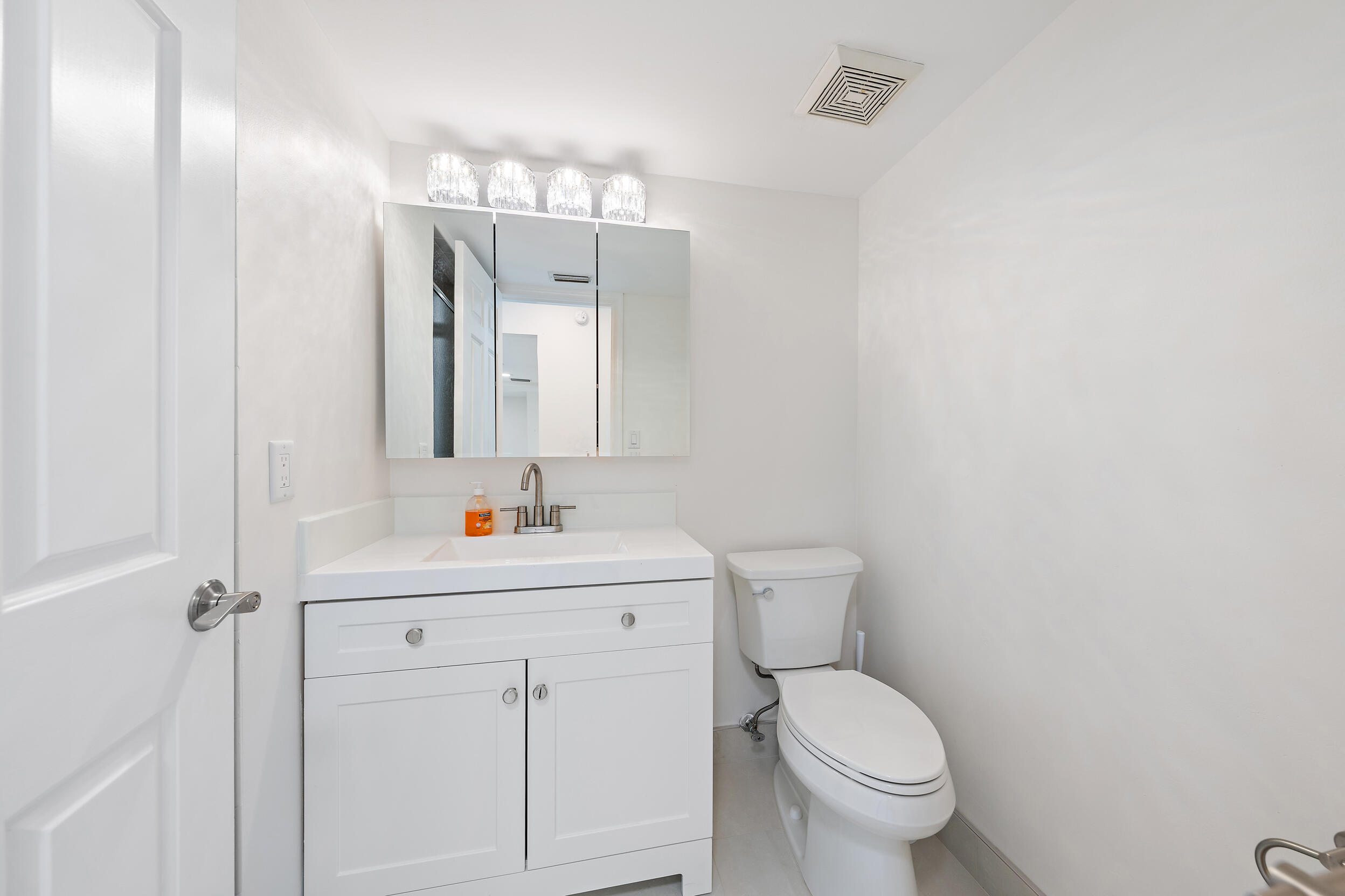 1000 North Us Highway, Unit 652 Jupiter, FL 33477 - Photo 35 of 64 a bathroom with a toilet a sink a mirror and vanity