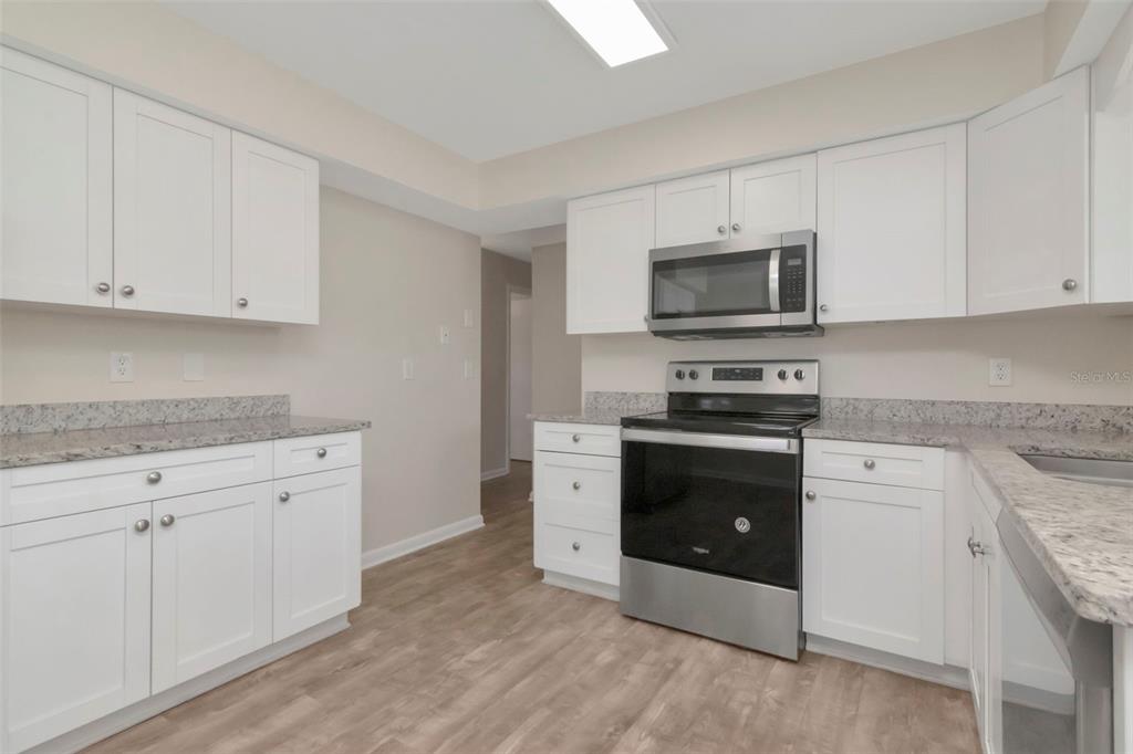 126 Kingsway Road Brandon, FL 33510 - Photo 19 of 42 a kitchen with granite countertop white cabinets and stainless steel appliances