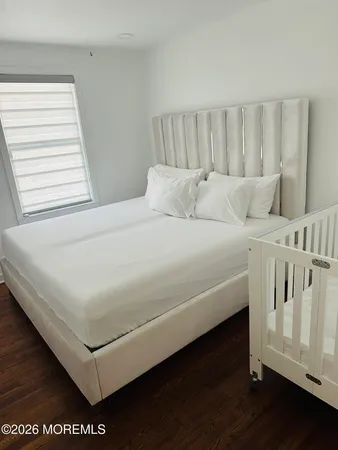 a white bed sitting in a bedroom next to a window