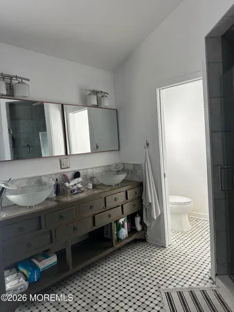 a bathroom with a sink a toilet and a mirror