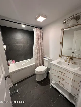 a bathroom with a double vanity sink toilet mirror and bathtub
