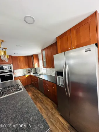 a kitchen with stainless steel appliances wooden cabinets a stove and a refrigerator