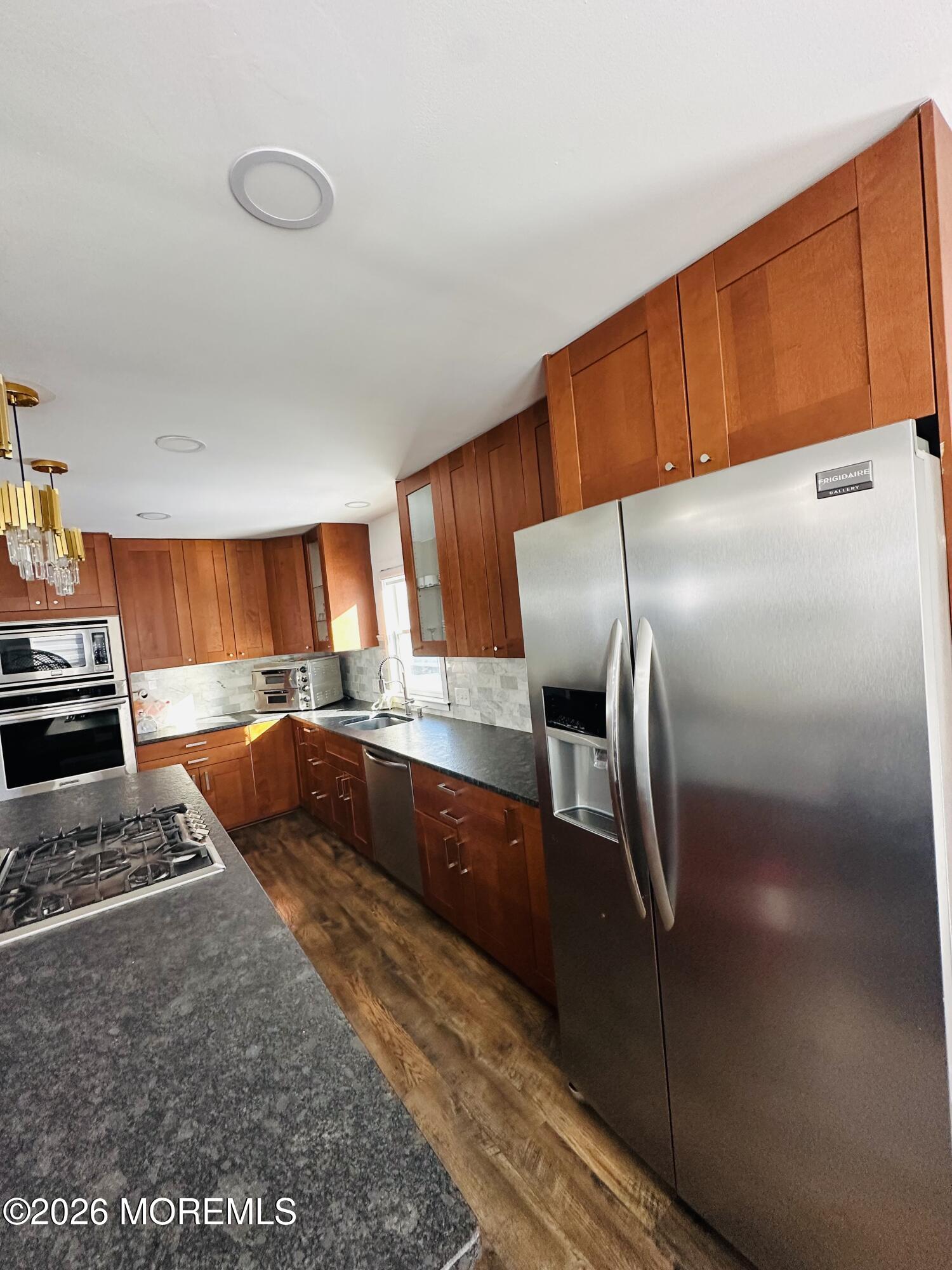 175 Delaware Avenue Oakhurst, NJ 07755 - Photo 7 of 24 a kitchen with stainless steel appliances wooden cabinets a stove and a refrigerator