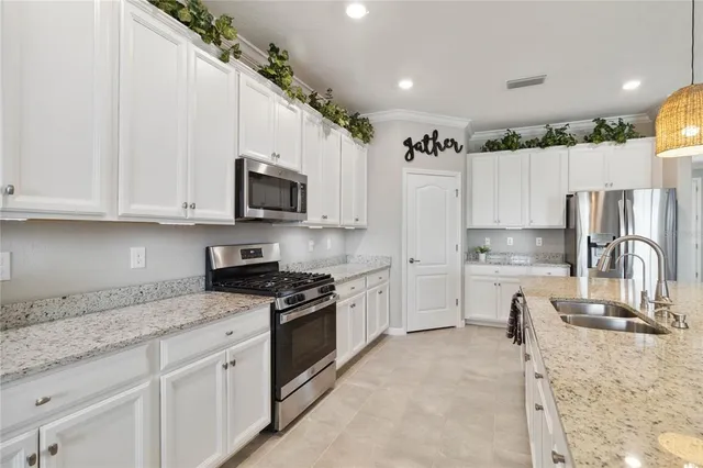 a kitchen with granite countertop a stove sink and refrigerator