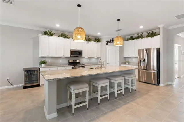 a kitchen with stainless steel appliances a table chairs and a refrigerator