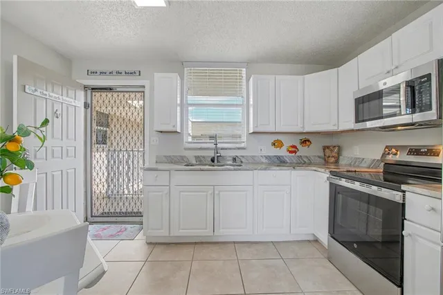 a kitchen with stainless steel appliances granite countertop a stove a sink and a white cabinets