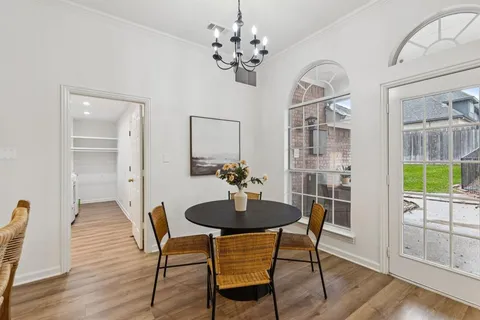 a view of a dining room with furniture wooden floor and chandelier