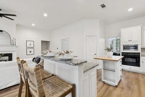a kitchen with stainless steel appliances granite countertop a stove oven and a refrigerator with white cabinets