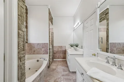 a bathroom with a tub sink and mirror