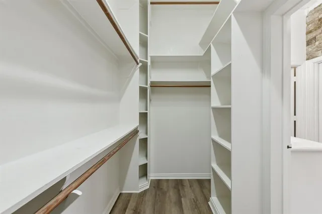 a view of walk in closet with empty racks