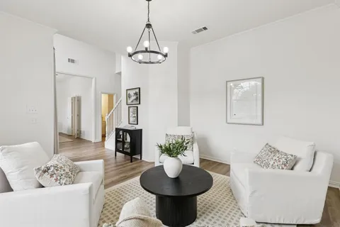 a living room with furniture a chandelier and a fireplace