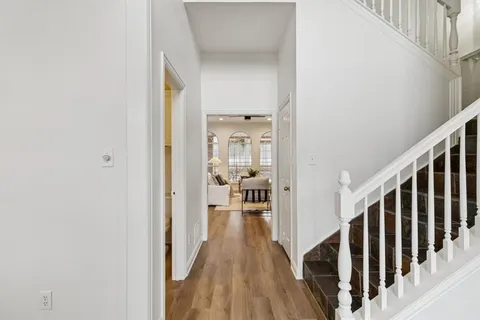a view of a hallway with wooden floor and staircase
